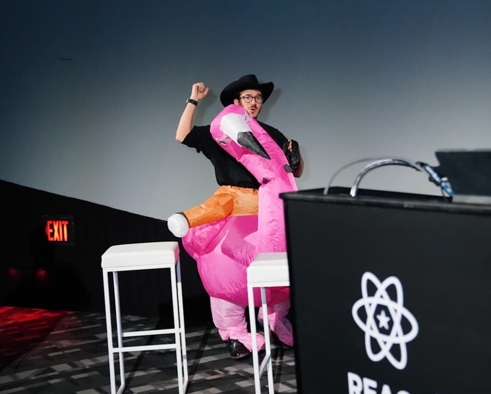 Swizec rides a flamingo onto the stage